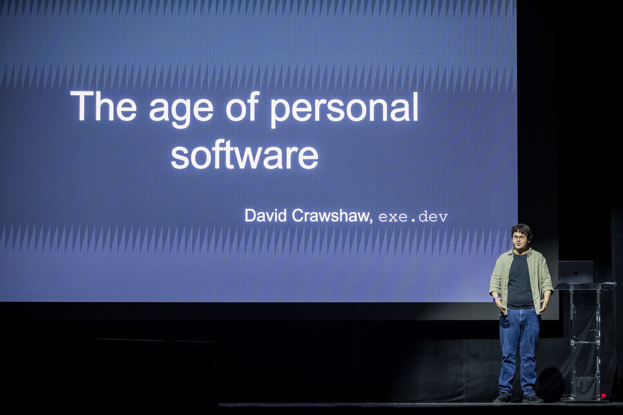 David Crawshaw on stage at Agent Night beside his title slide, “The age of personal software.”