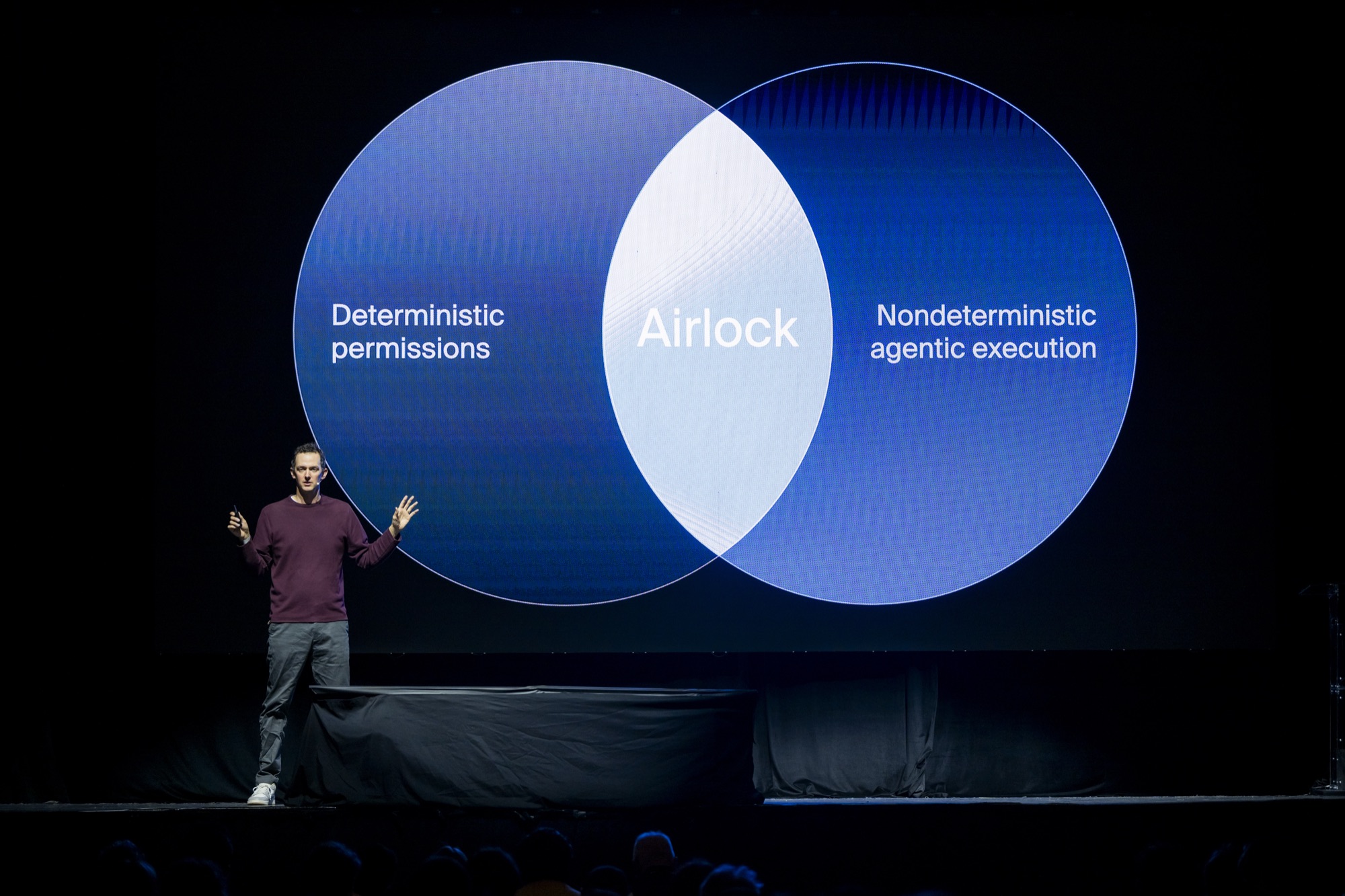 Michael Grinich on stage at Agent Night, presenting the Airlock keynote slide showing deterministic permissions and nondeterministic agentic execution overlapping in a Venn diagram.