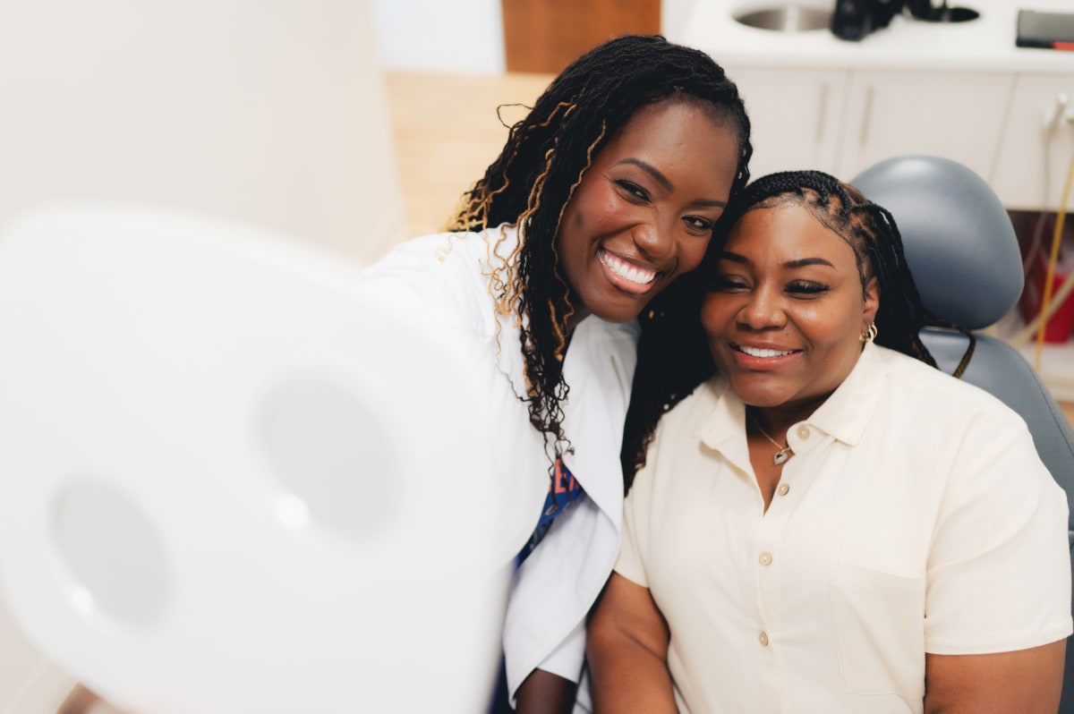 Female dental professional examining a young patient's smile in clinical setting