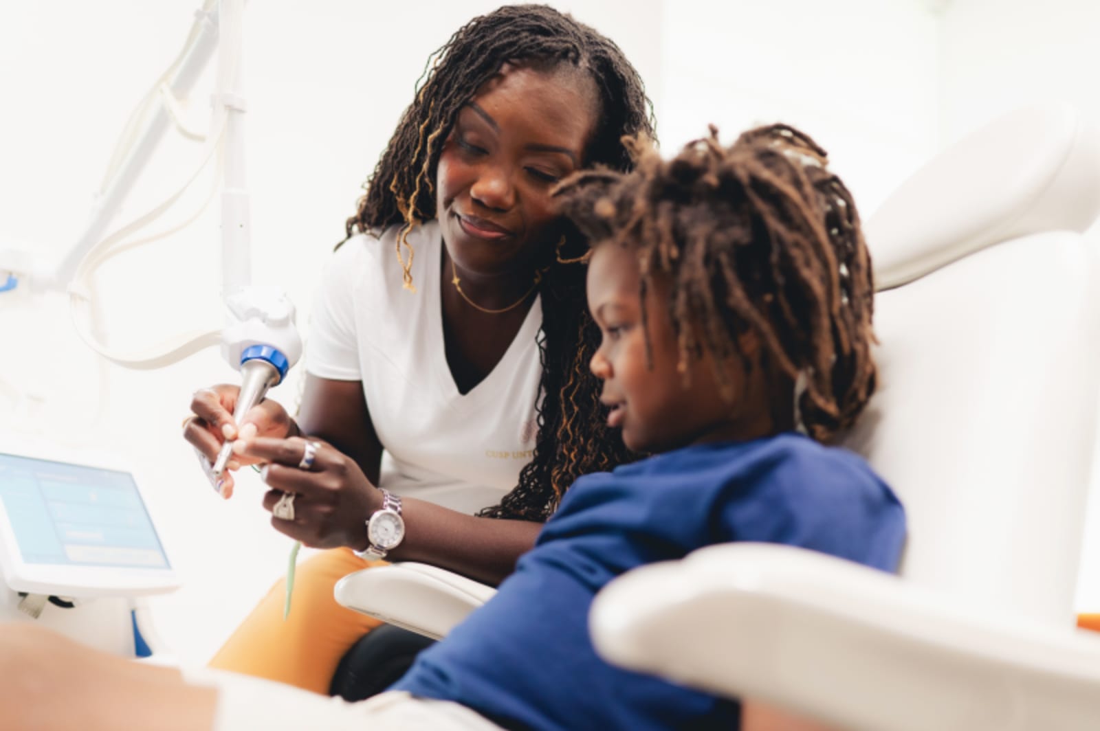Dentist demonstrating tooth shade selection to patient during consultation