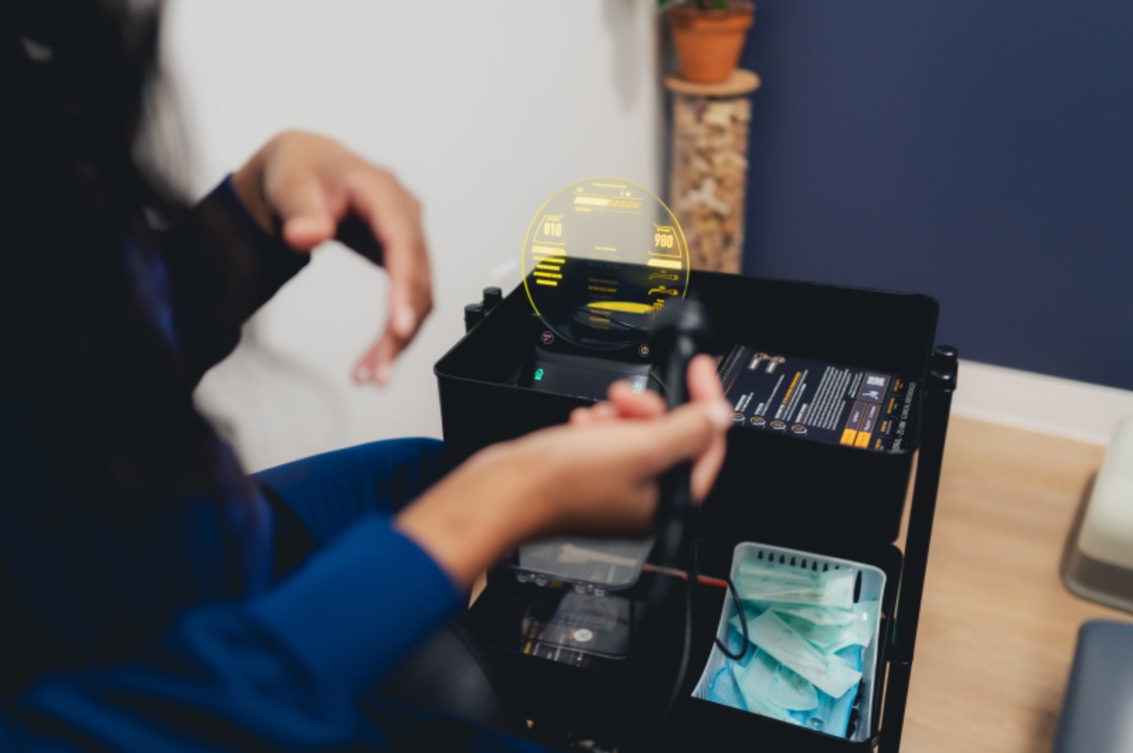 Technician examining dental lab materials and equipment at workstation.