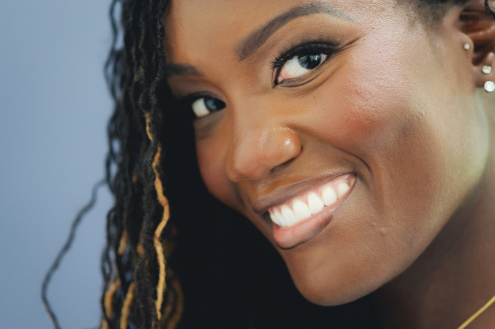 Woman smiling brightly, showcasing healthy white teeth