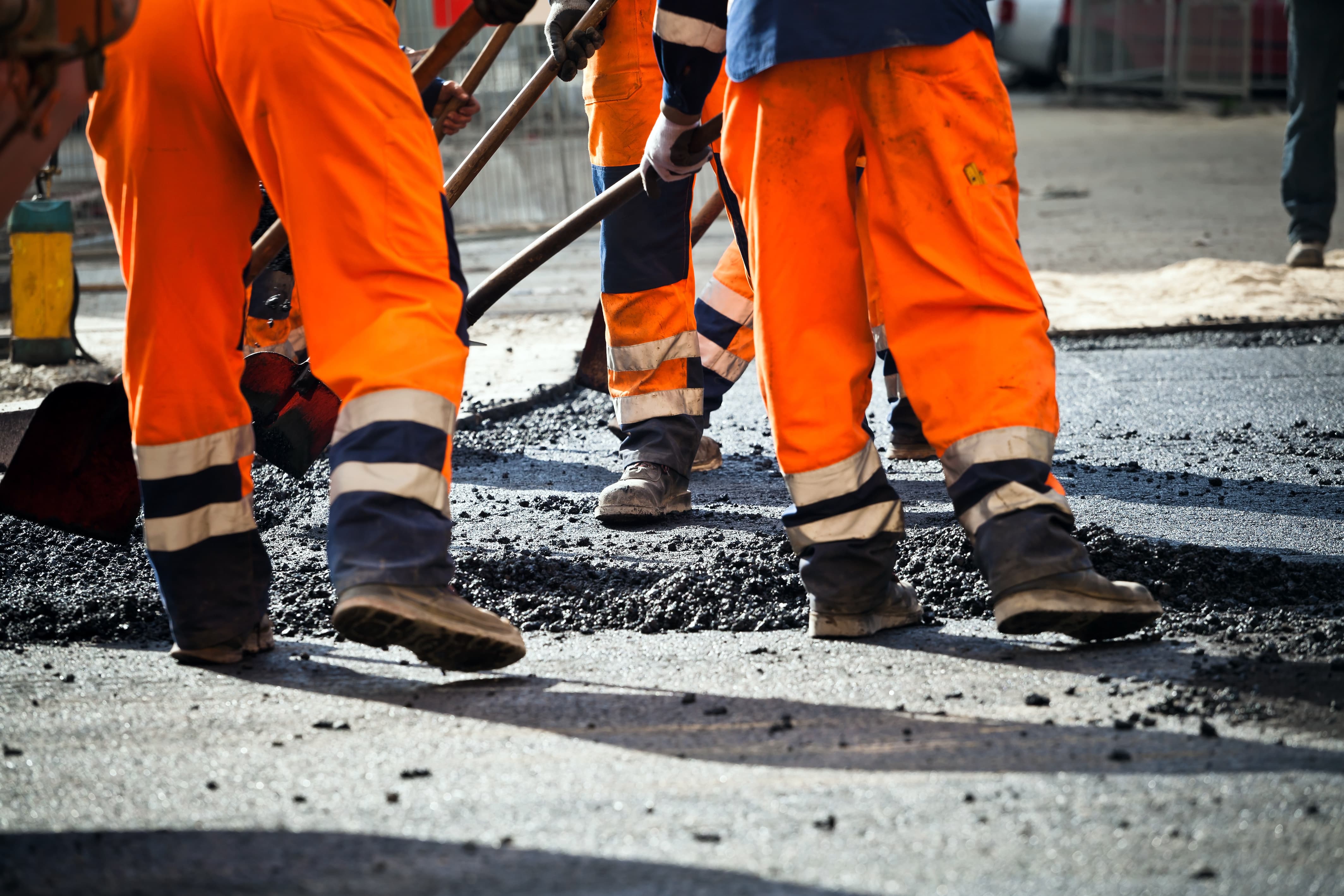 Workers in bright orange working on a street