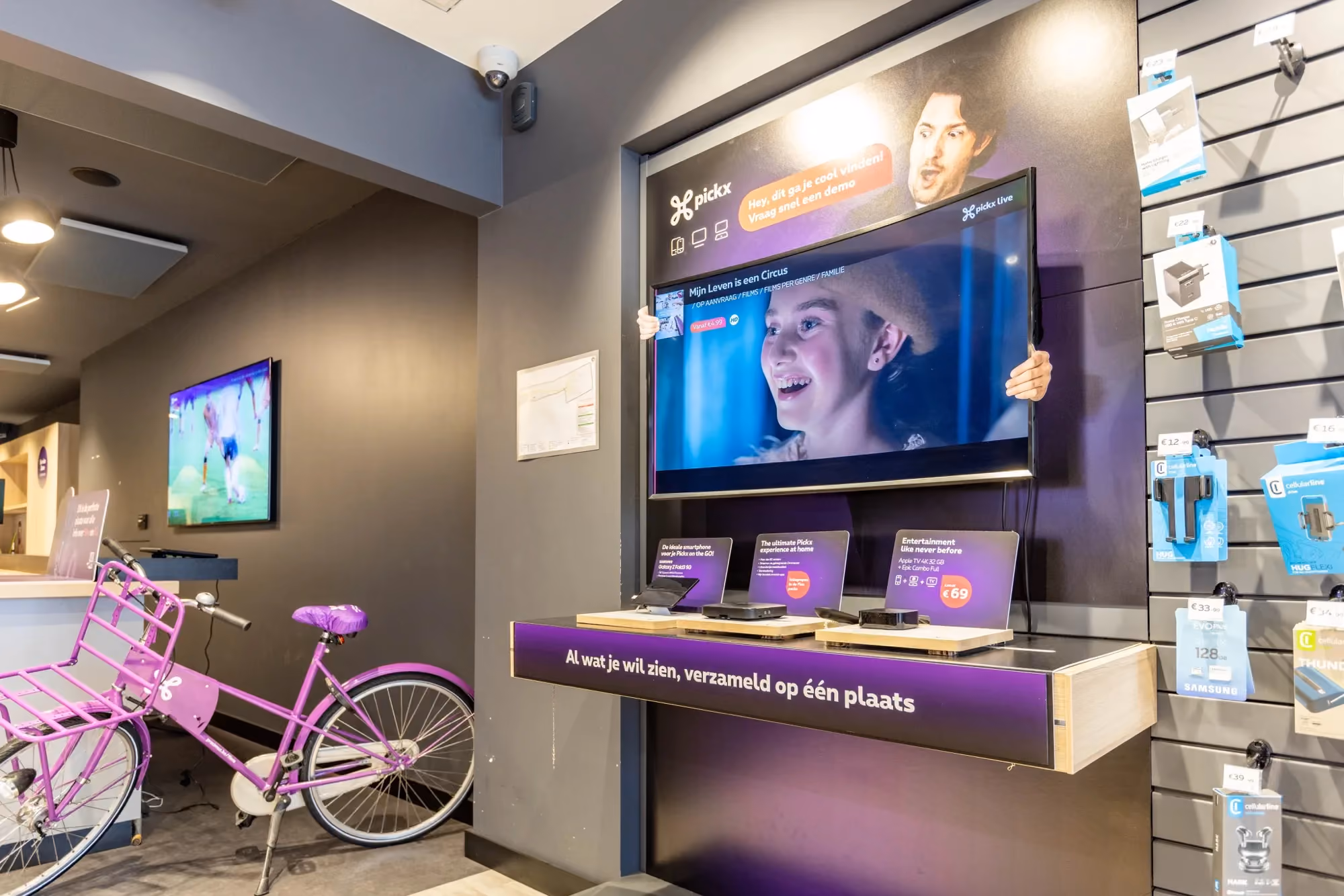 Proximus store accessories wall and Pickx TV display with a cargo bike in the aisle