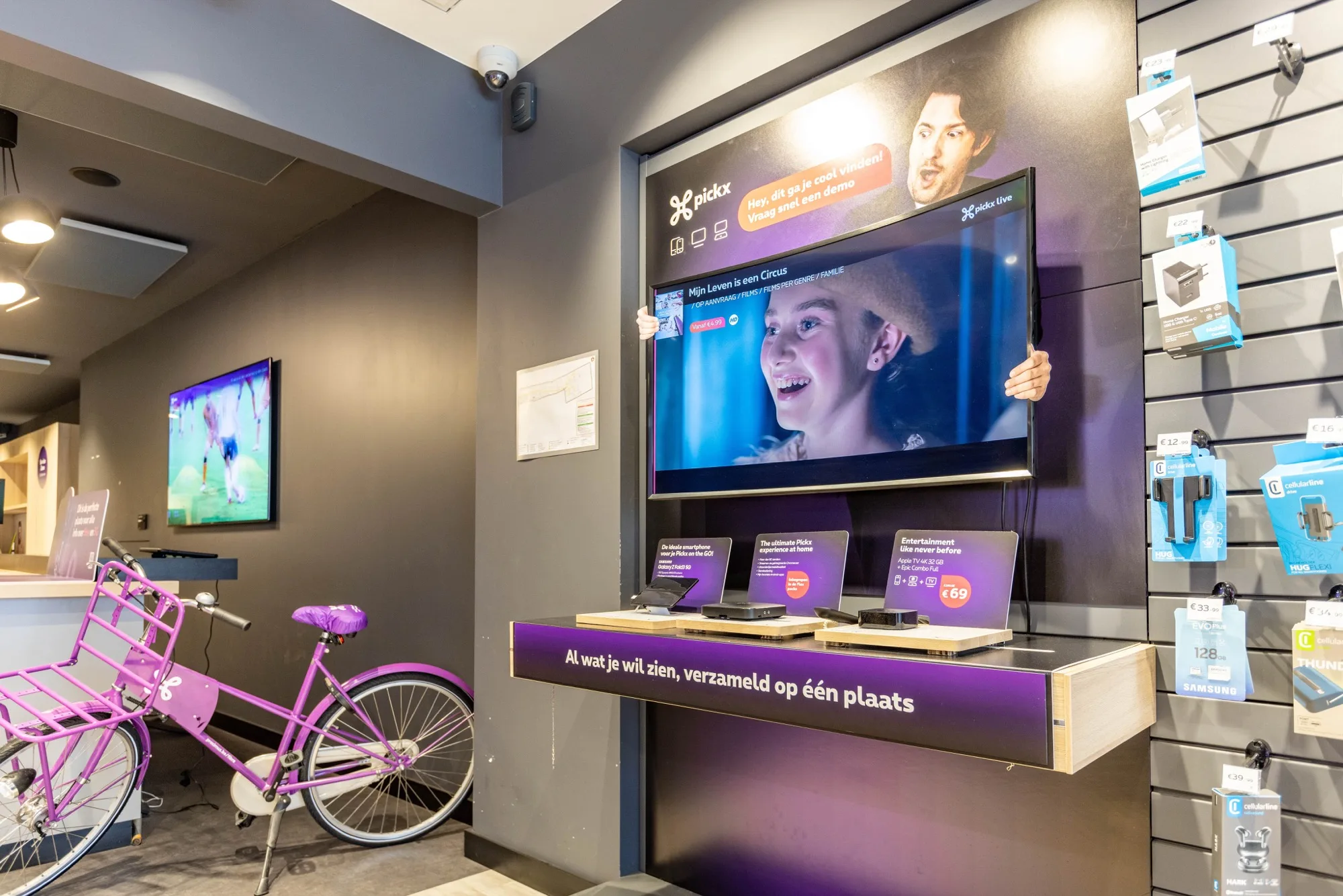 Proximus store accessories wall and Pickx TV display with a cargo bike in the aisle