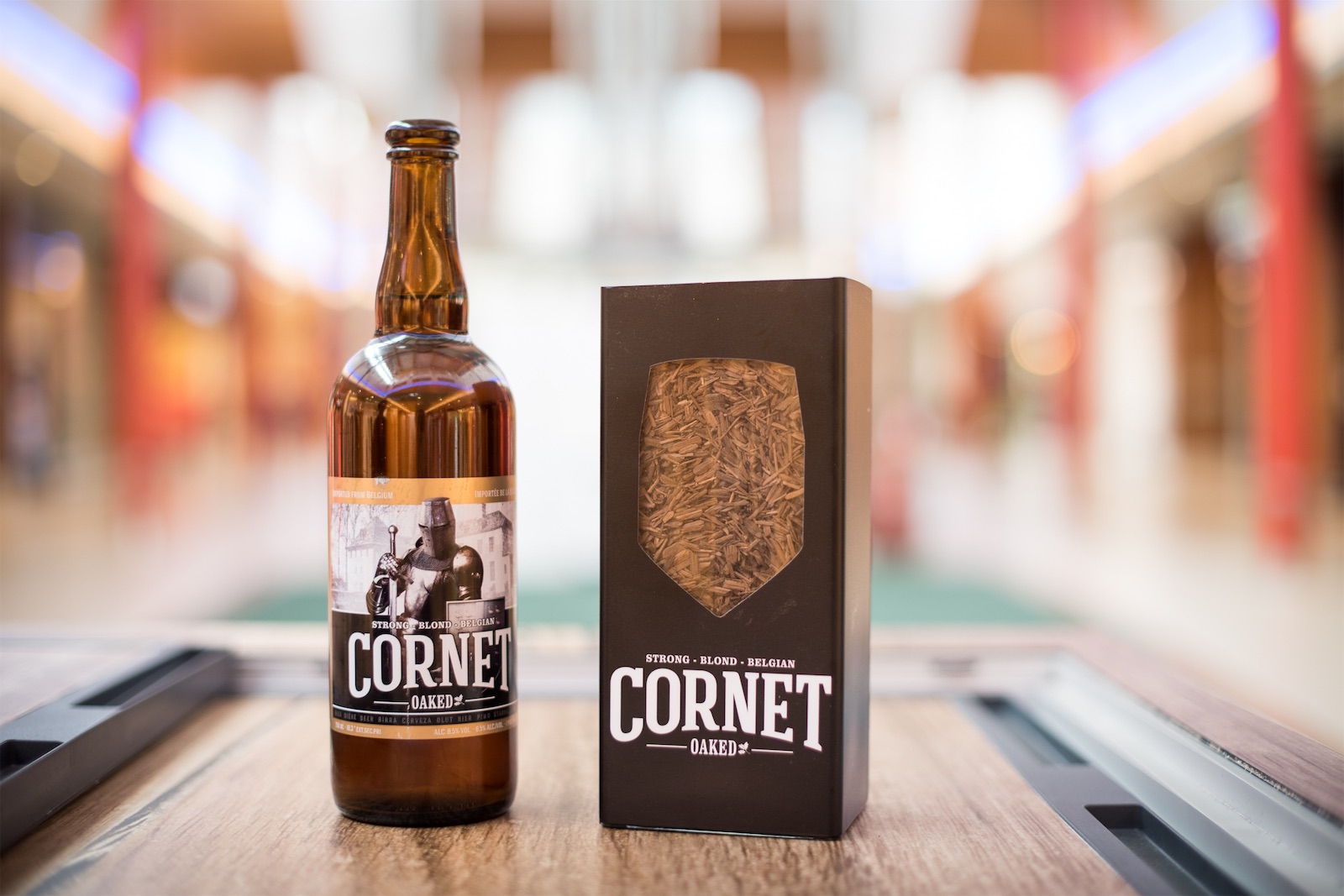 Bottle and gift box of Cornet Oaked strong Belgian blond beer displayed in a shopping mall, part of a Field & Concept retail activation