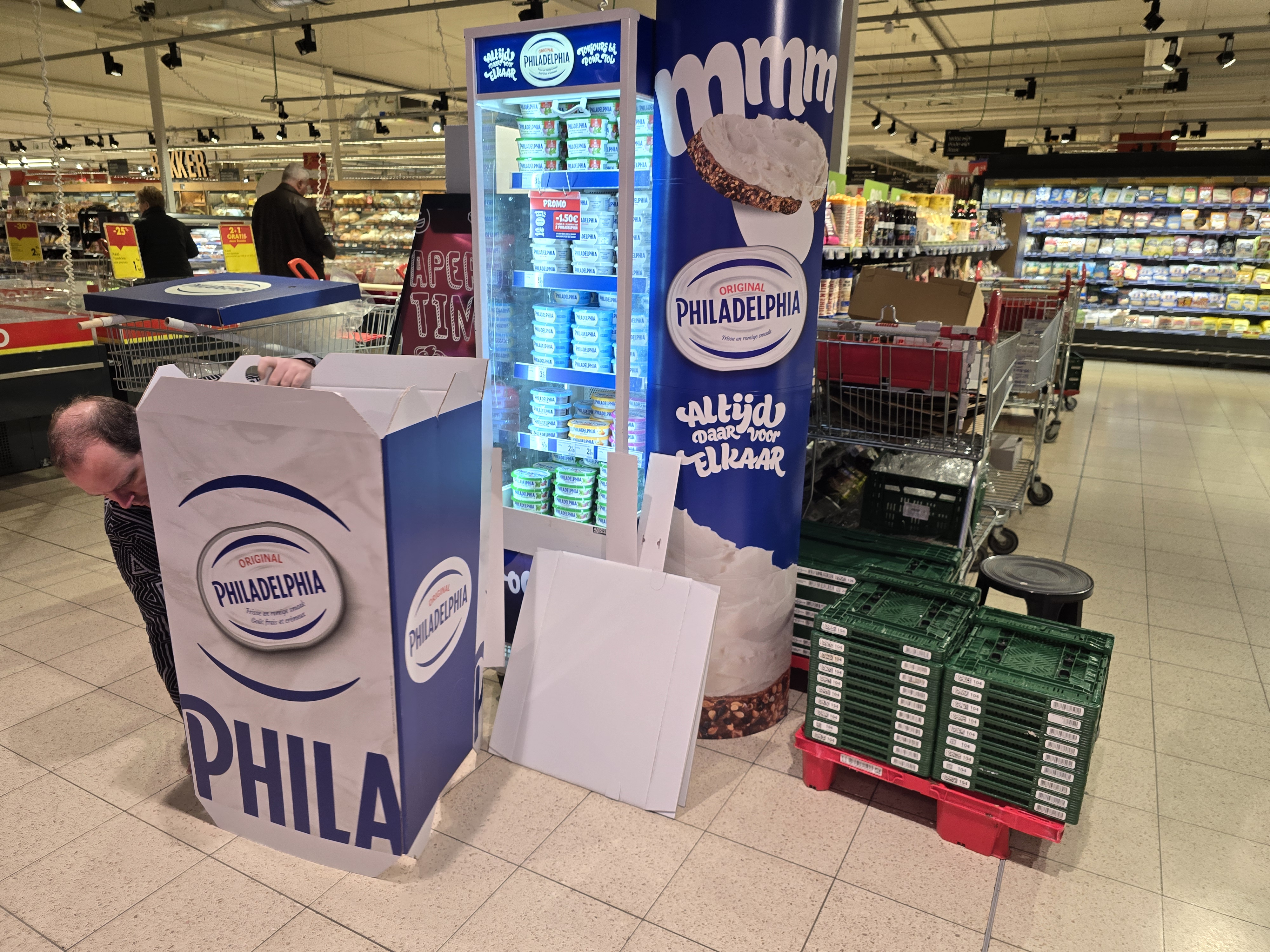 Field & Concept Philadelphia cream cheese in-store display being assembled in a Belgian supermarket, with promotional signage and stacked cardboard packaging