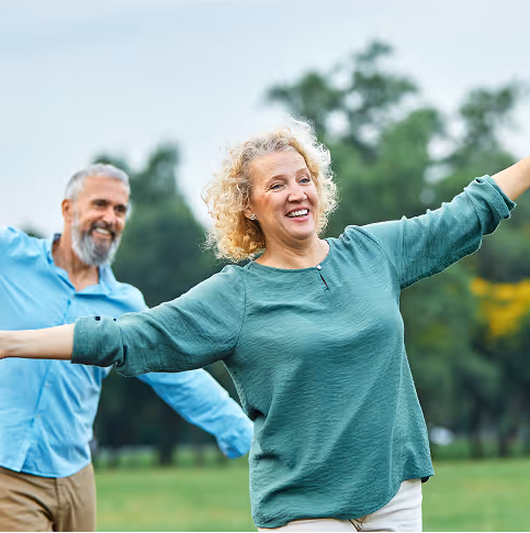 Older couple smiling and stretching outdoors