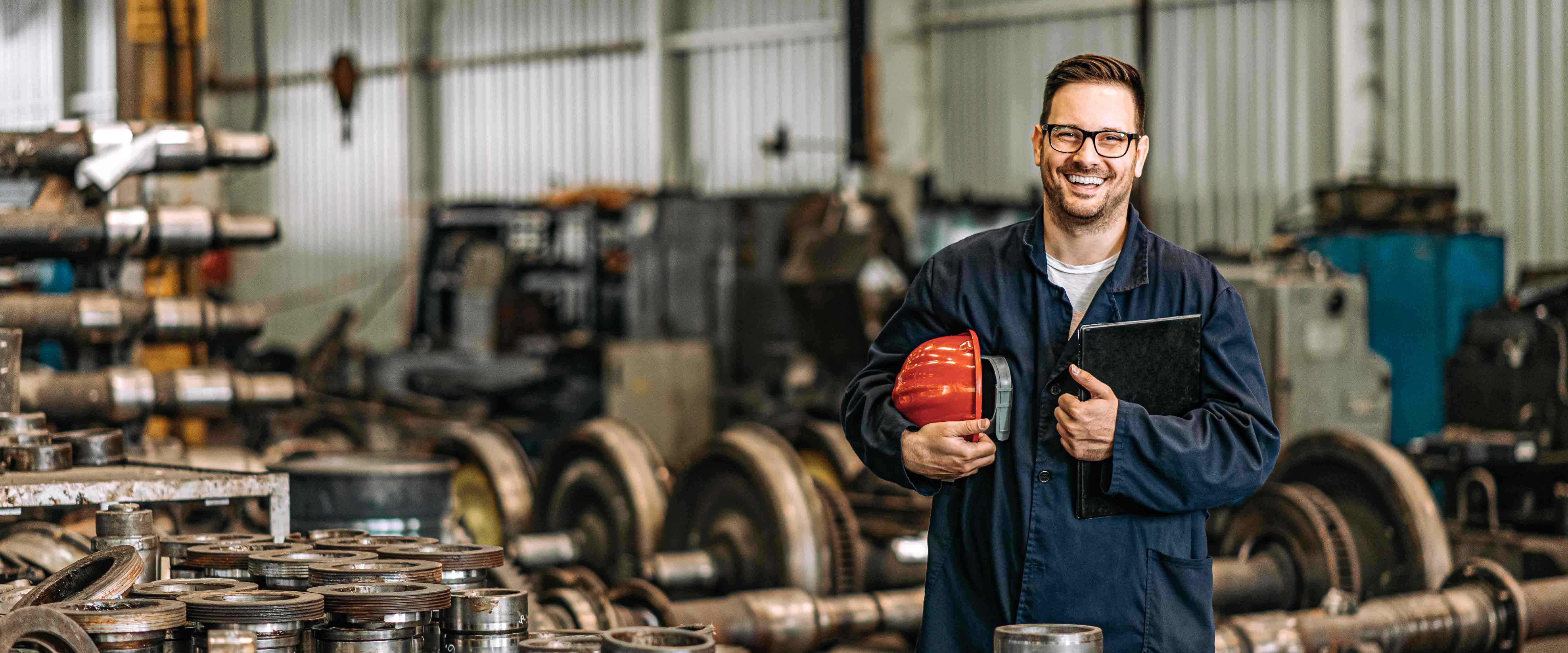 Worker holding helmet smiling at camera