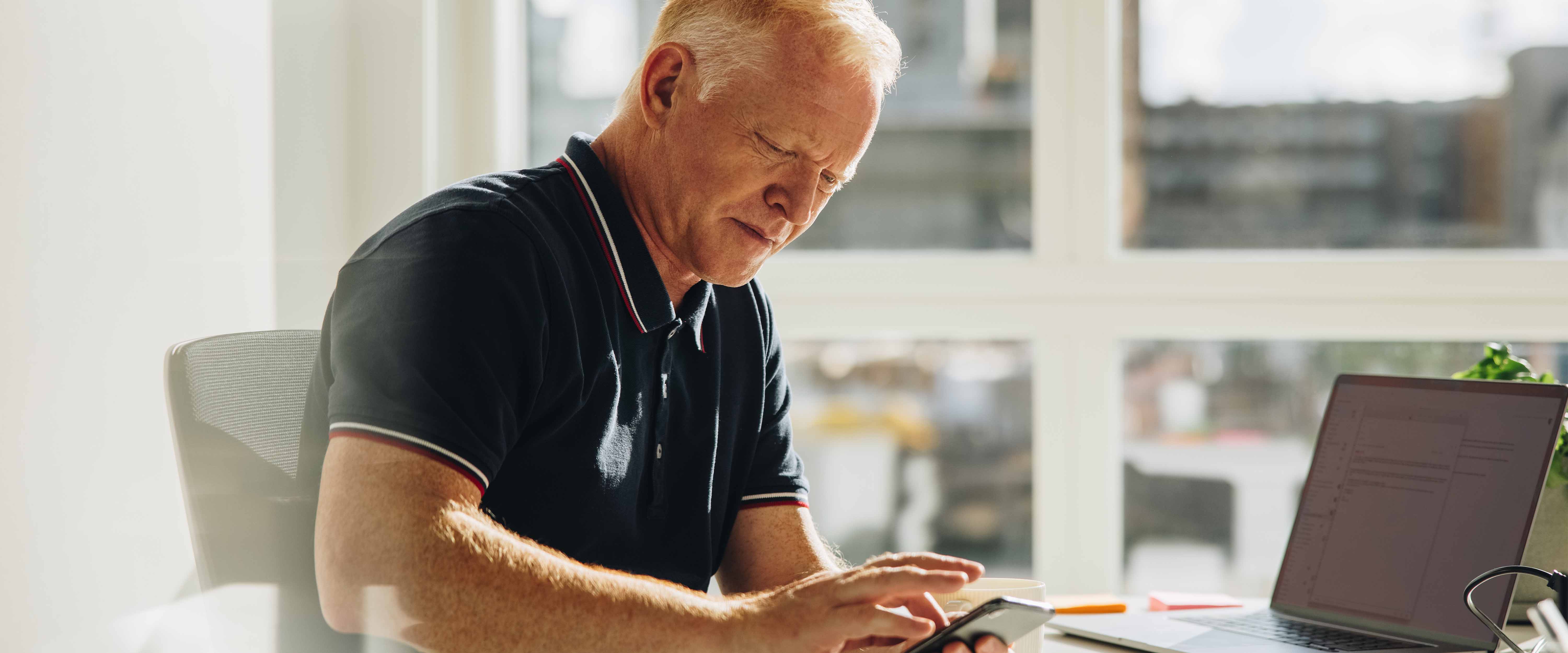 Man at desk on phone and computer.