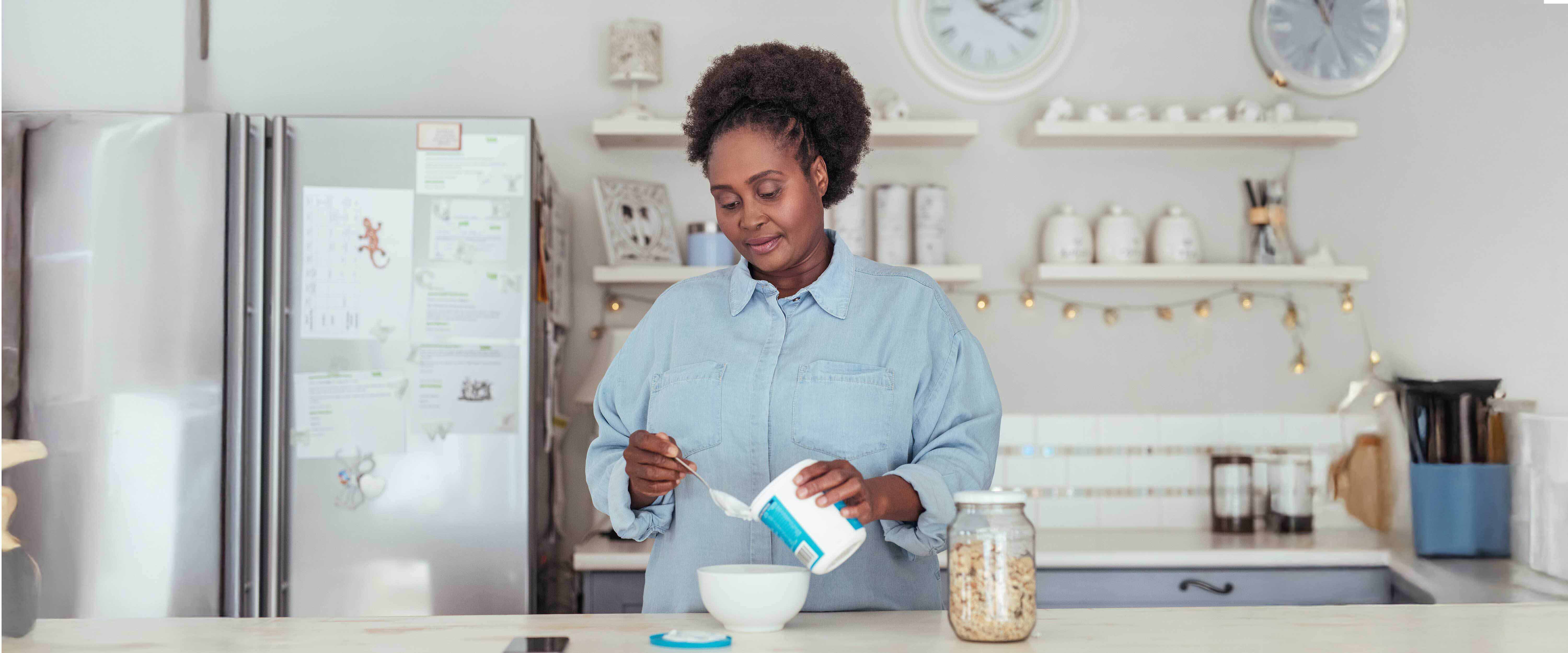 Woman in kitchen portioning yogurt