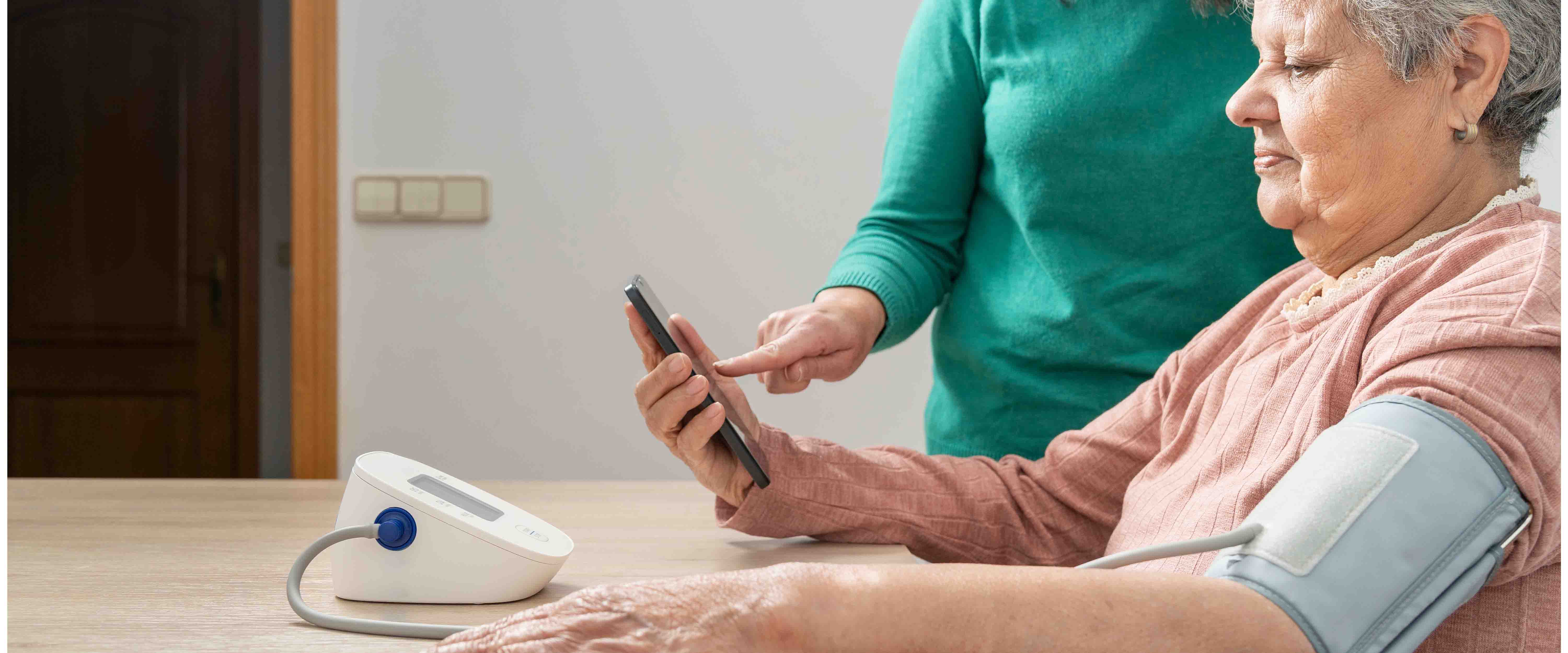 Woman monitoring blood pressure at home