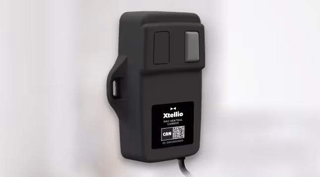 An Xtellio Pro Xentral CANBus device placed on a table in a blurred and bright environment