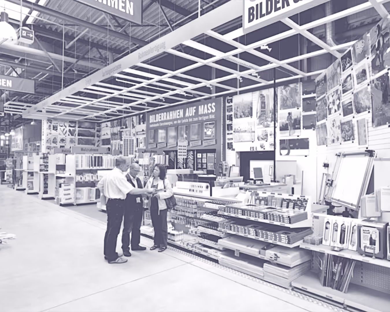 Das Innere eines HORNBACH-Marktes. Drei Personen unterhalten sich in einem Gang.