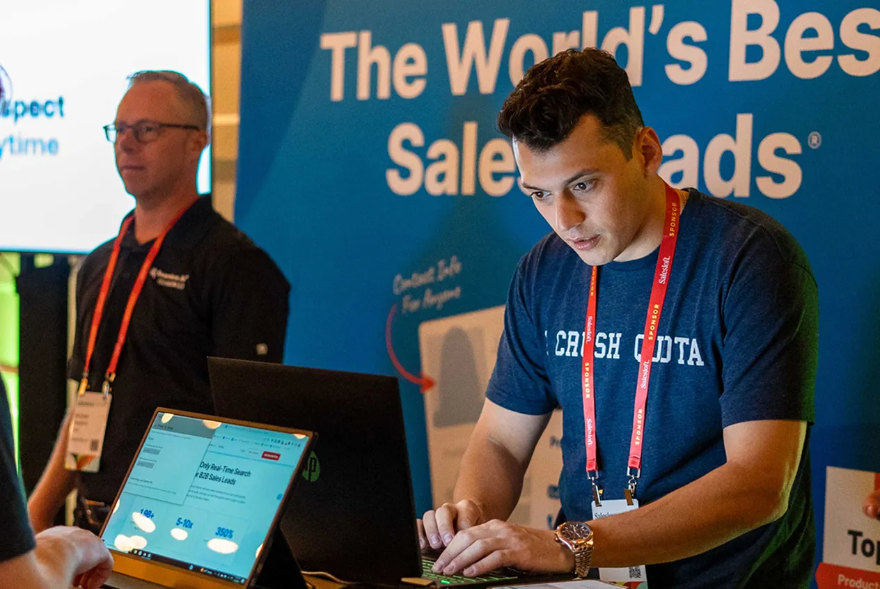 Candid photo of 2 Seamless employees working at an event booth together.