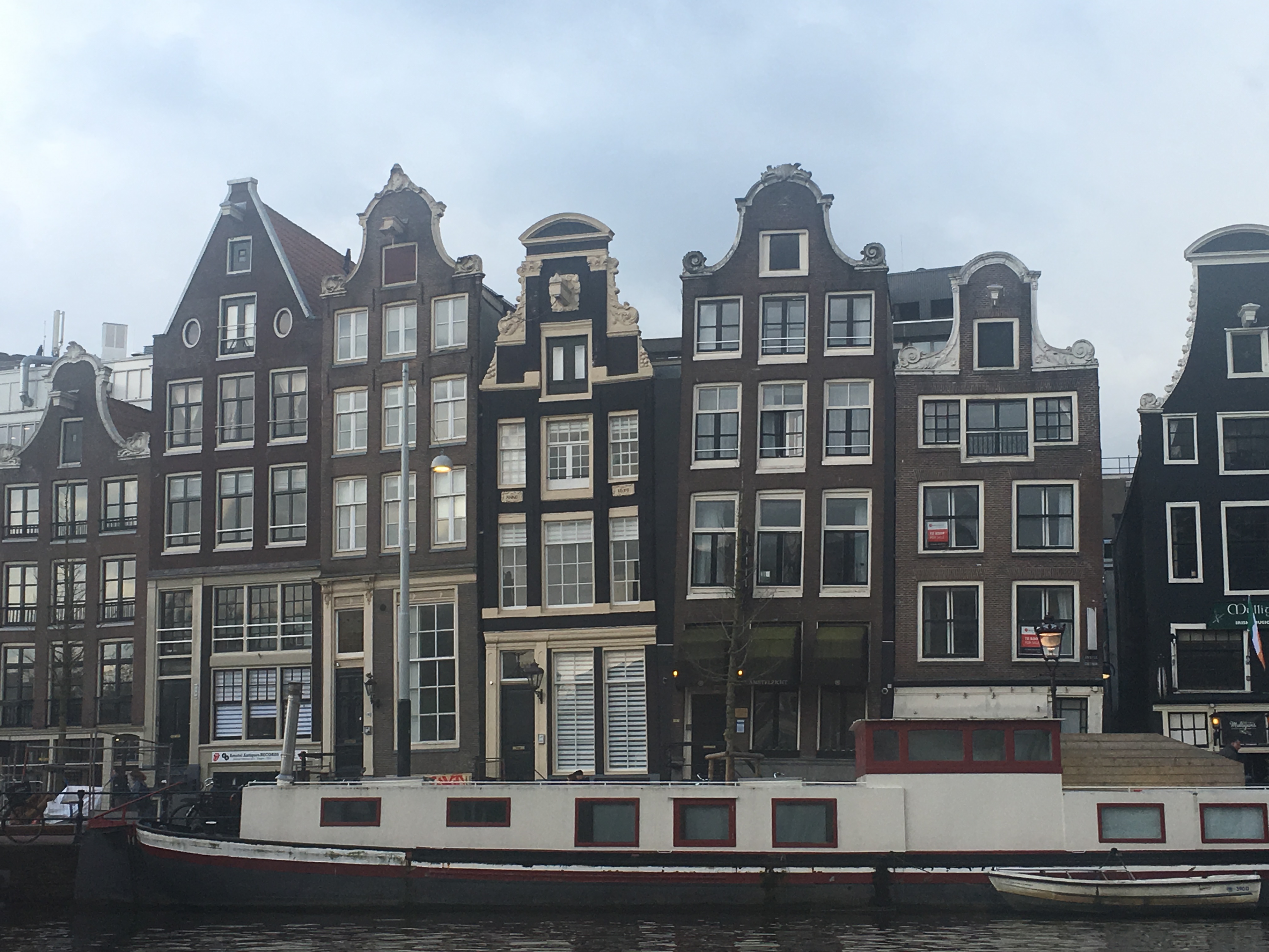 Historic canal houses and a houseboat along an Amsterdam waterway