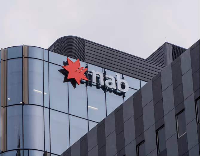 Glass and dark panelled building corner with a red star and the letters 'nab' logo mounted on it.