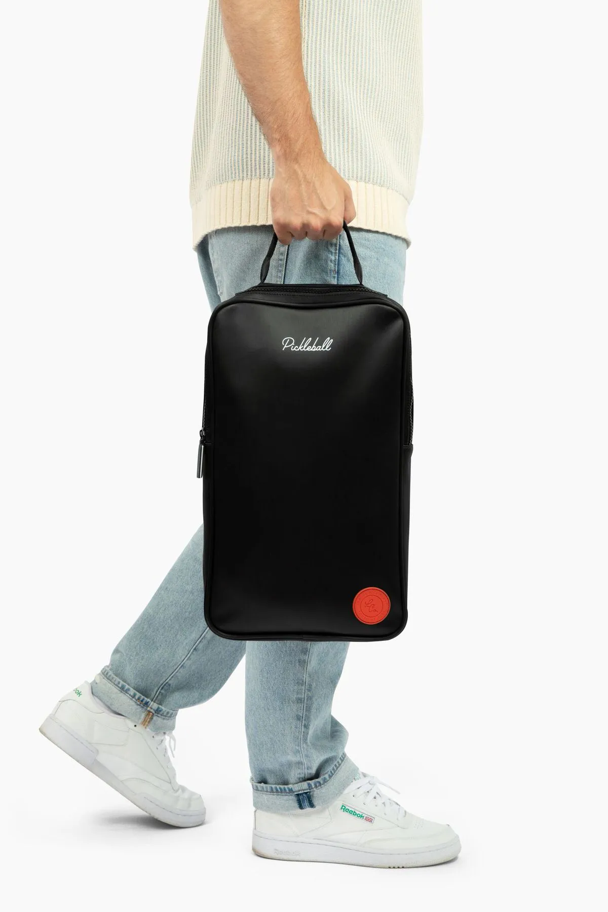 a full body model holding a black backpack