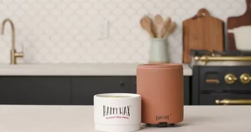 A close-up of a wax warmer and scented wax melts on a kitchen counter, styled with a cozy, modern background.