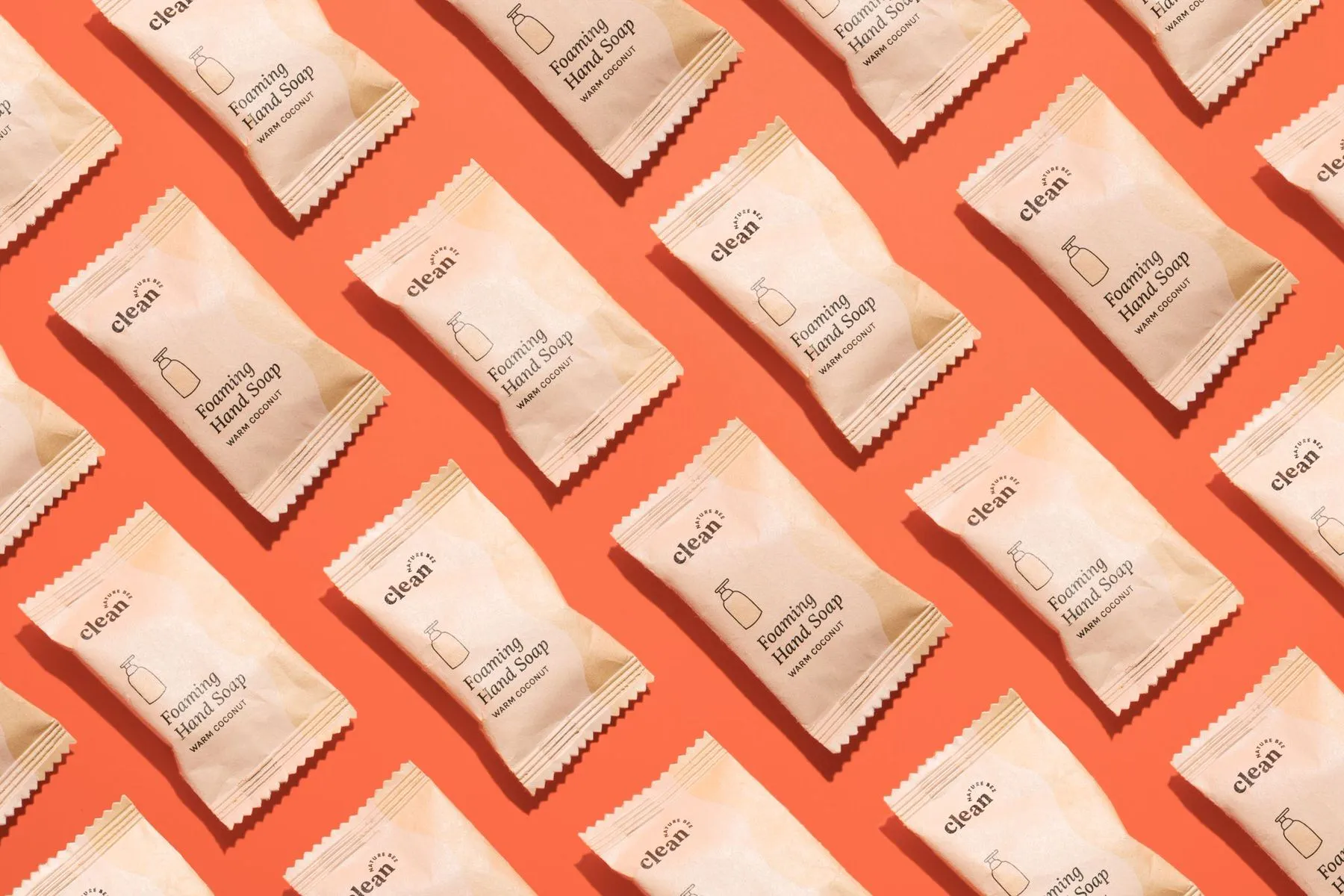 two gold earrings on a tan backdrop