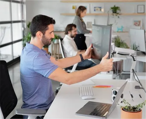 Man adjusting monitor at Branch office workstation