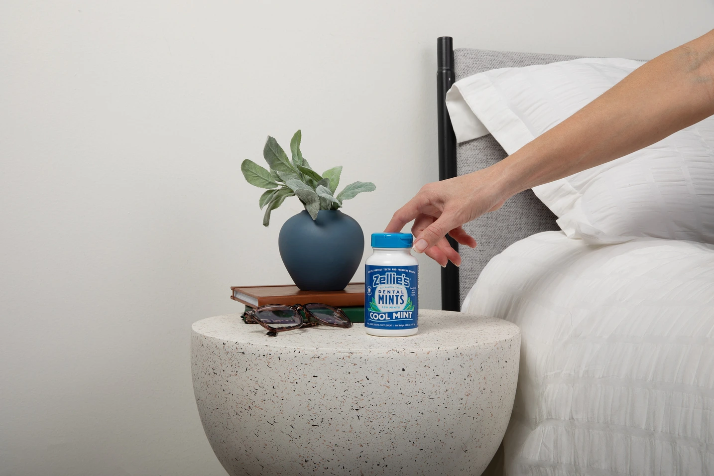 hand reaching for bottle of minds on a nightstand