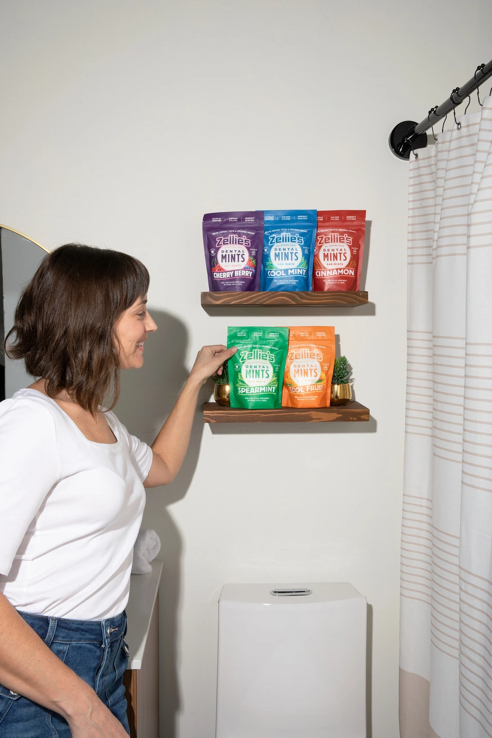 woman selecting a bag of mints in a bathroom