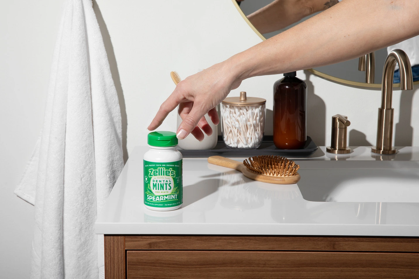 hand reaching for bottle of mints in a bathroom