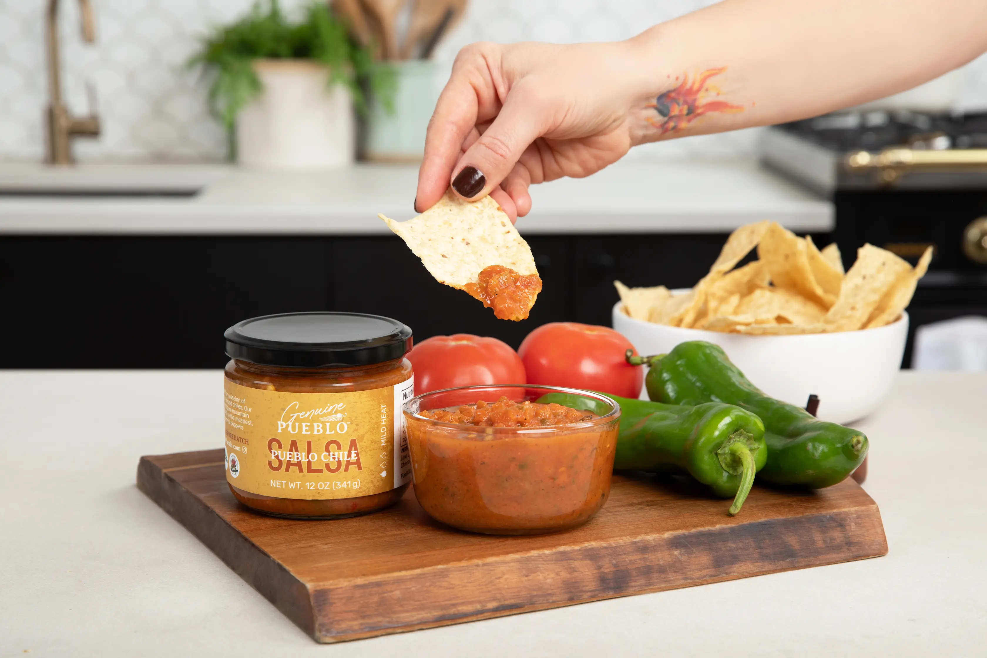 hand dipping chip in dip in kitchen