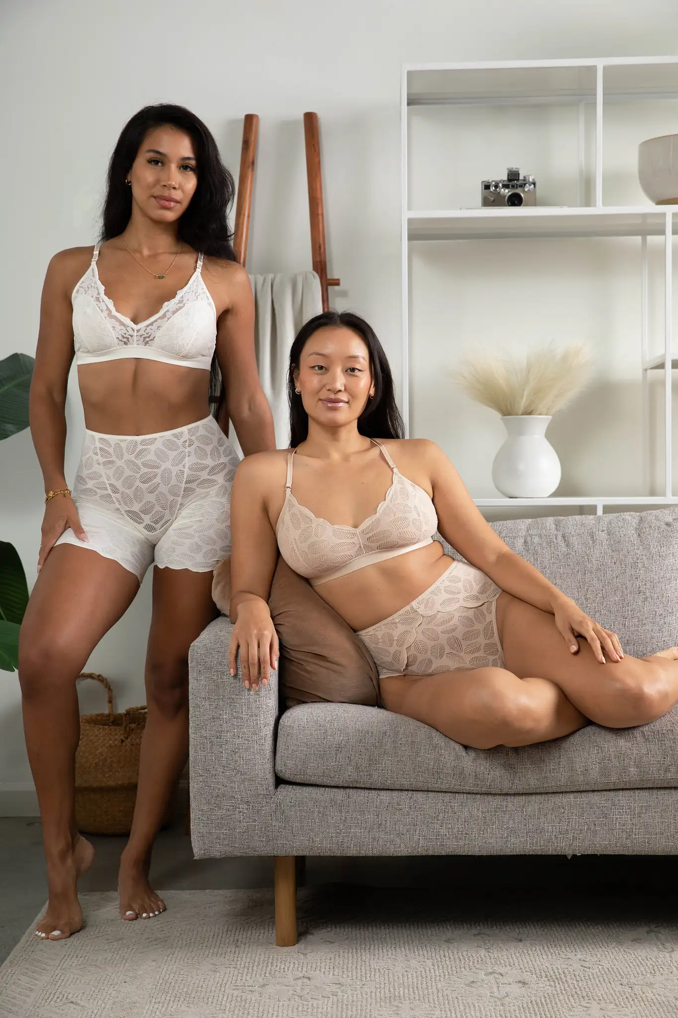two models in underwear posing in a living room