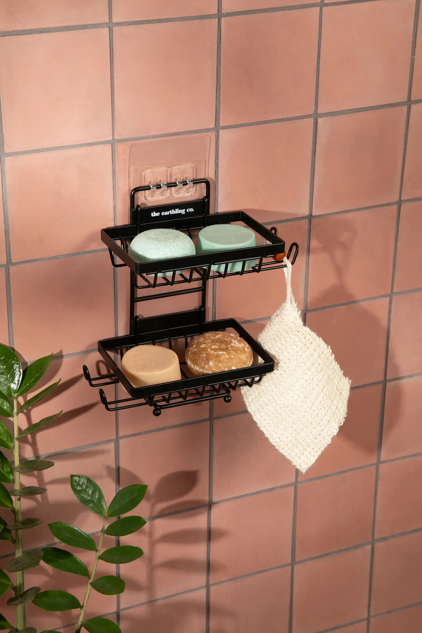 soap sitting on a soap dispenser on a pink tiled shower wall