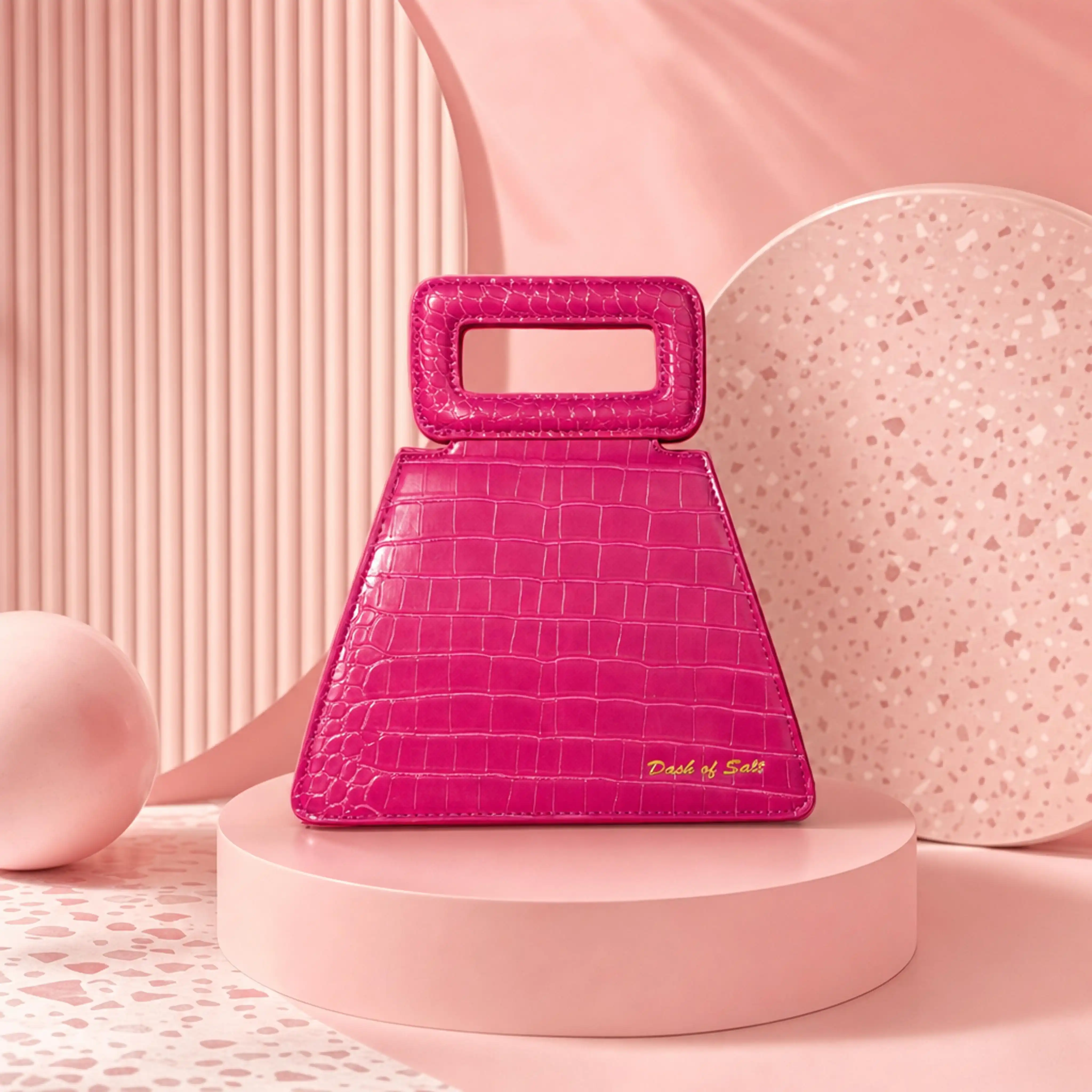 Bright pink crocodile-texture handbag with rectangular handle displayed on a round pink pedestal.