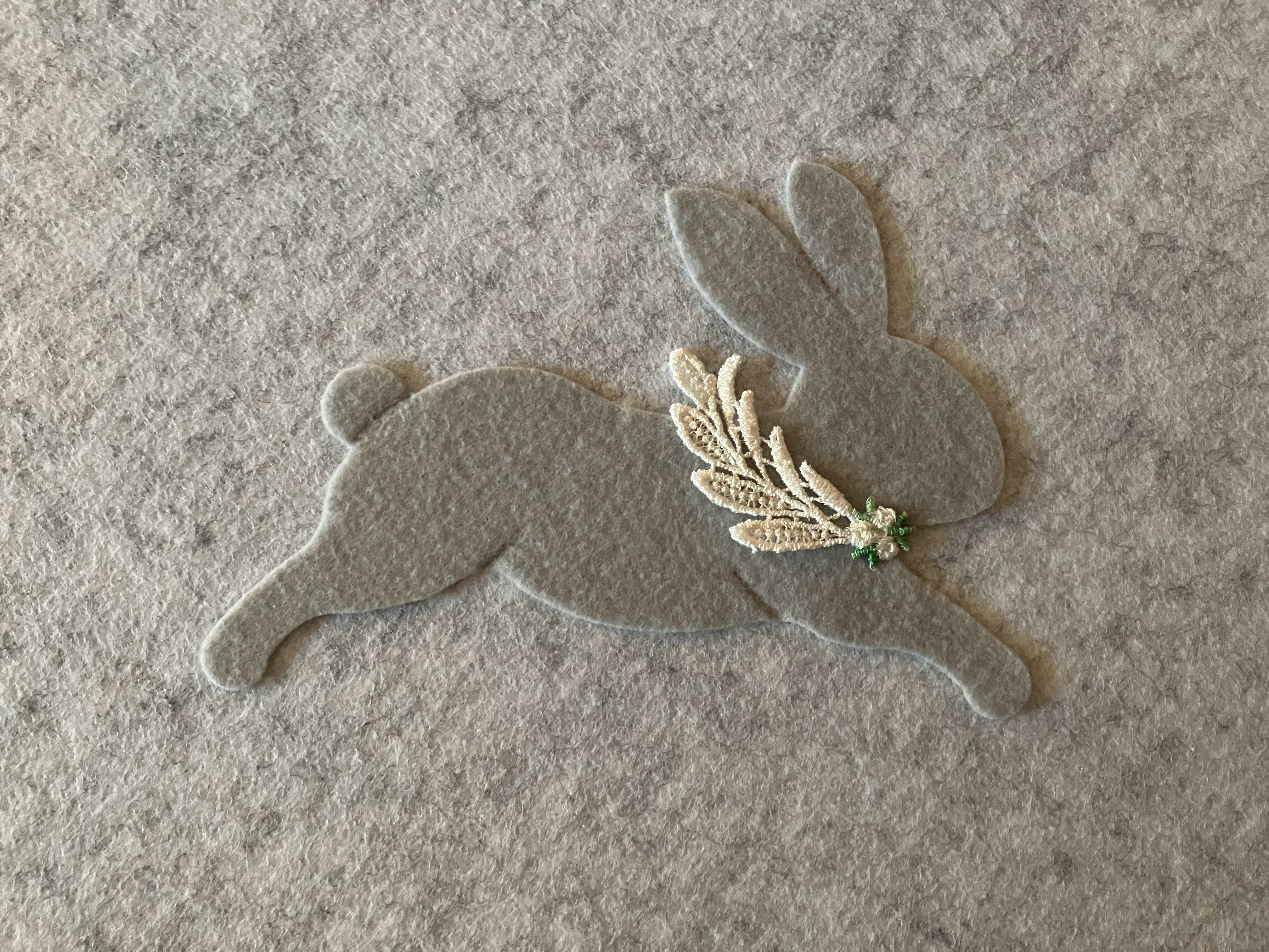 Felt rabbit decorated with a flower/leaf design, attached to an acoustic panel in a Montessori-style nursery for a hard of hearing child