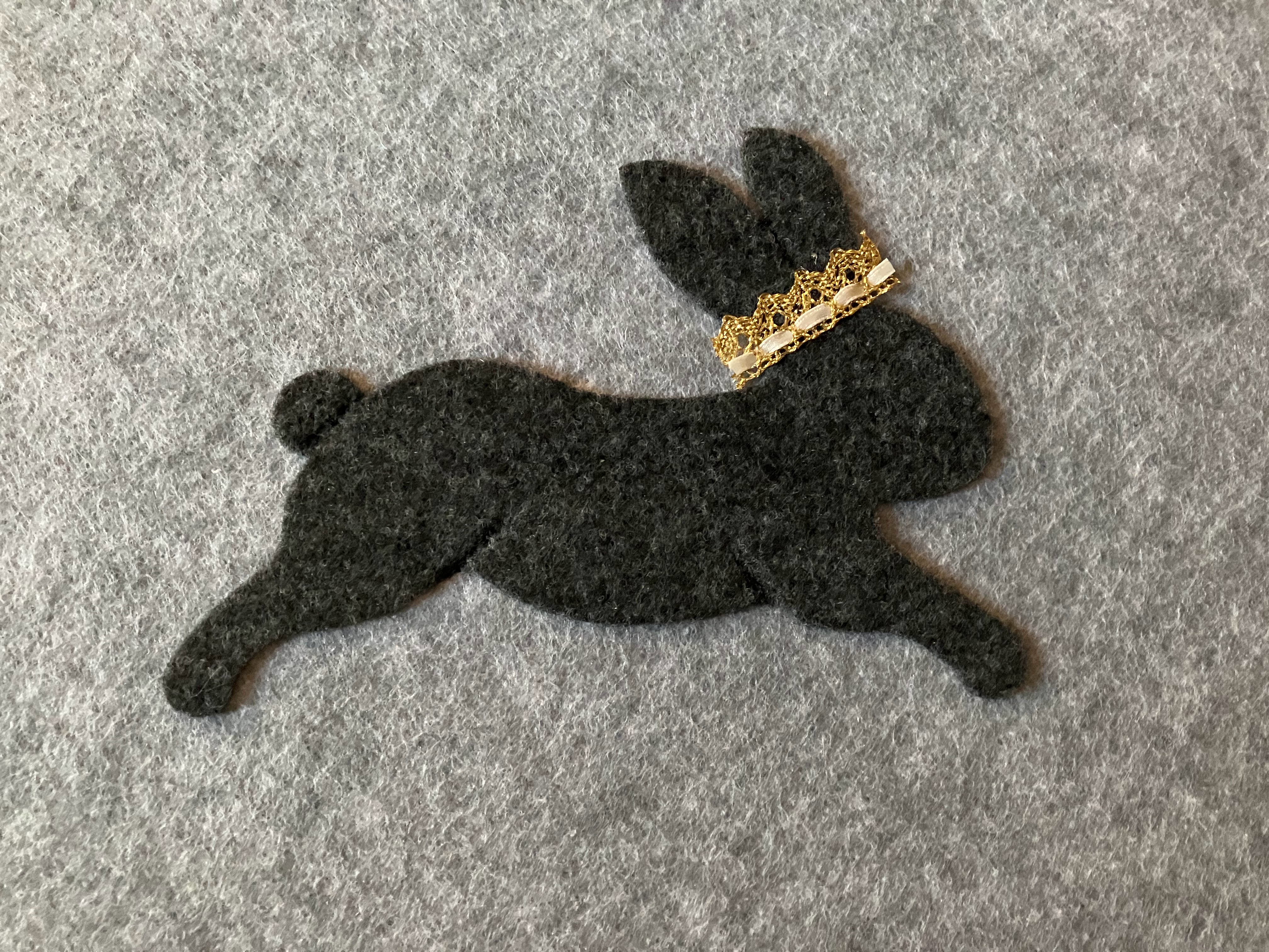Felt rabbit decorated with a crown design, attached to an acoustic panel in a Montessori-style nursery for a hard of hearing child