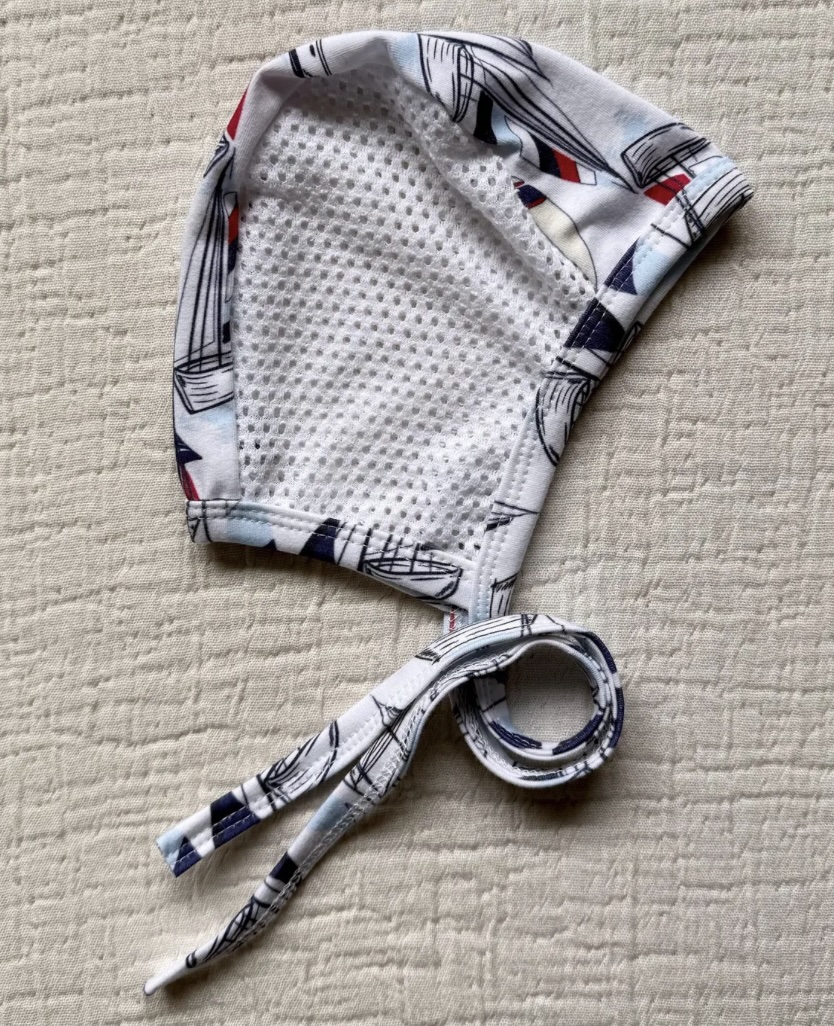 Emmifaye hearing aid bonnet with sailboat print and mesh lining, includes ties