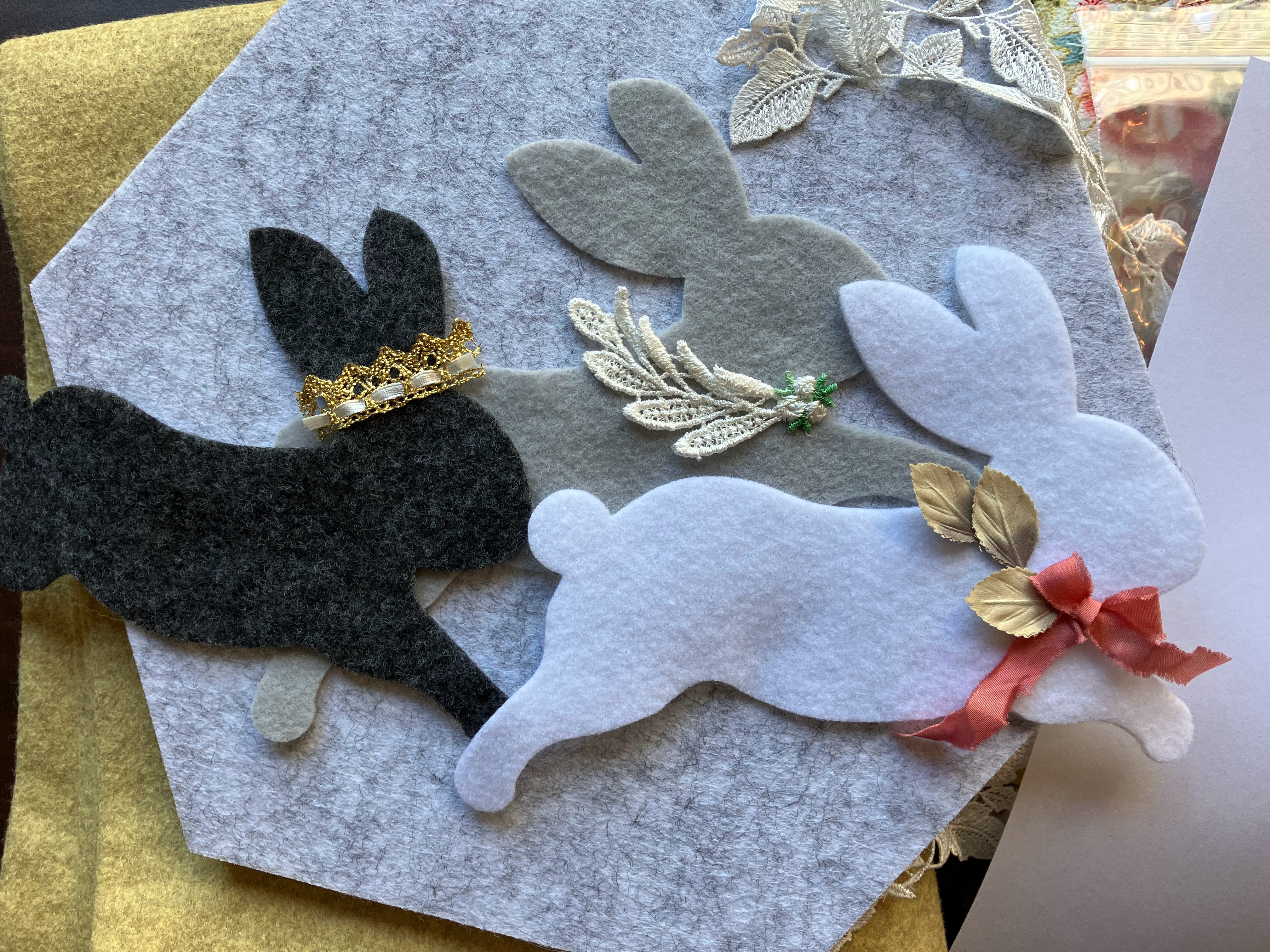 Decorated felt rabbits with bows and botanical details on light blue acoustic panel for child's bedroom sound control