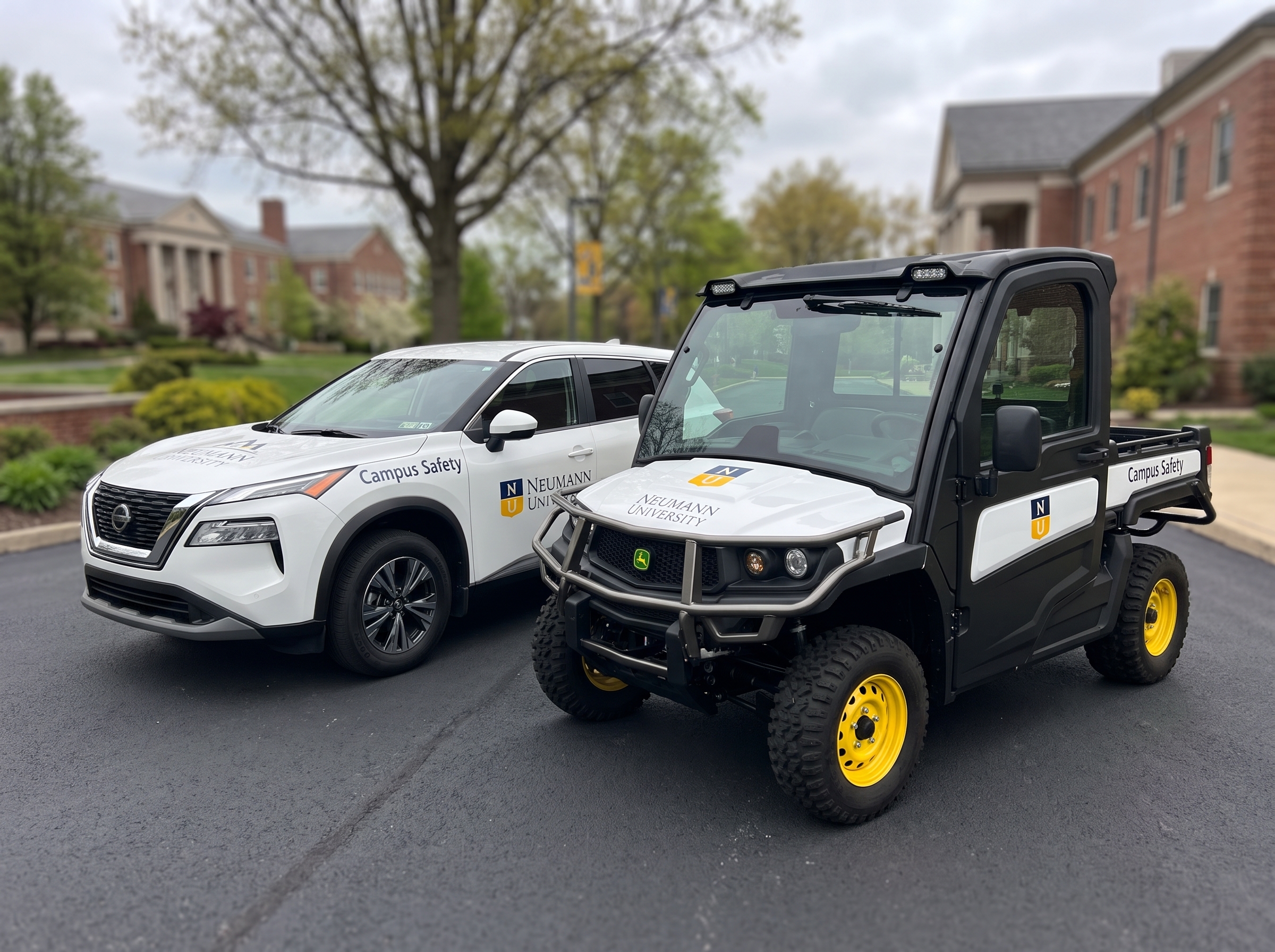 White SUV and utility vehicle with matching fleet logo graphics for Neumann University