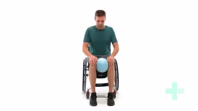 Man in wheelchair exercising with fitness ball