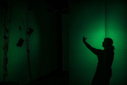 Two people sit at a round table in a kitchen area, engaged in conversation. The background shows kitchen appliances and cabinets.