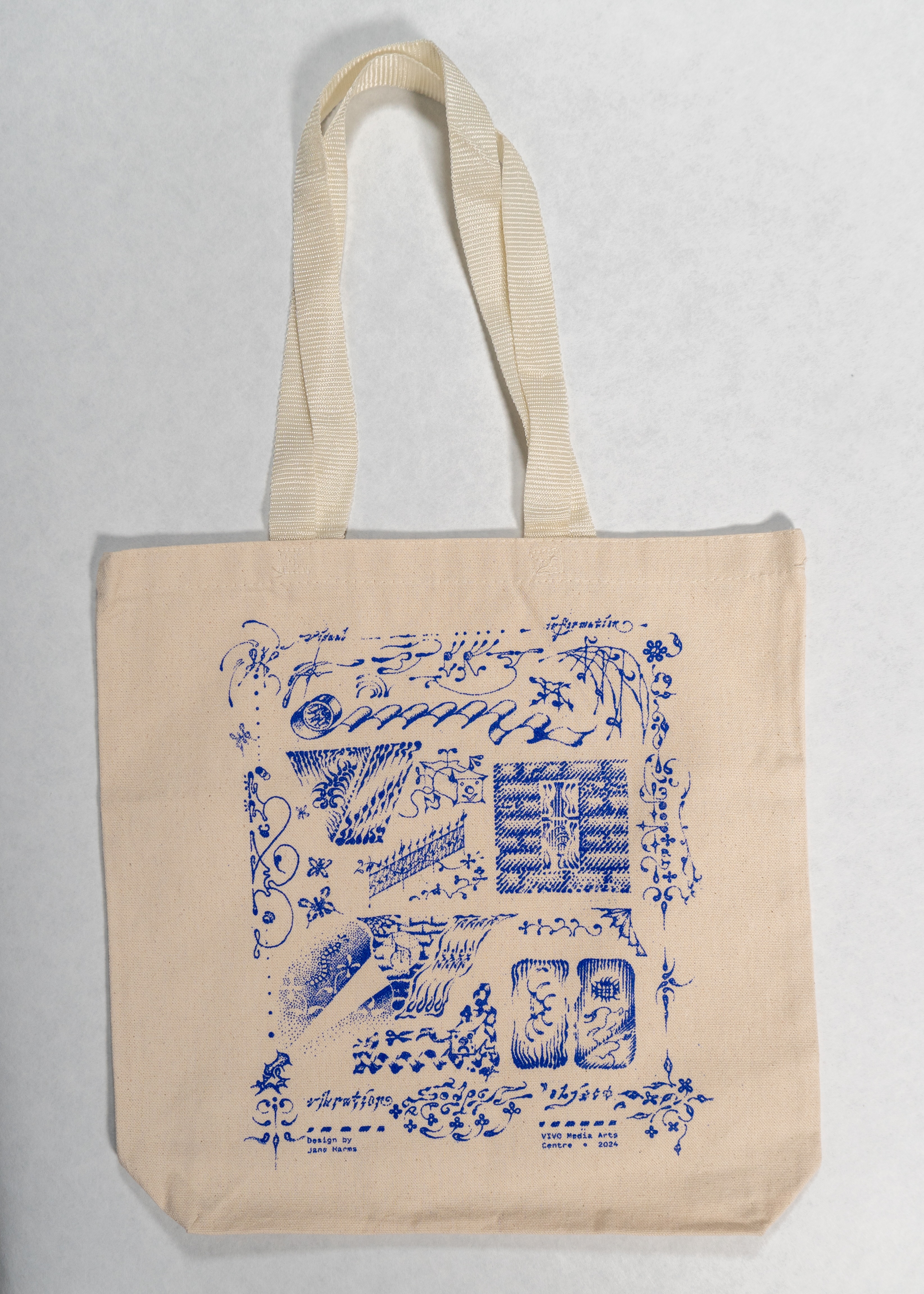 A beige canvas tote bag with a blue print featuring a variety of stylized sketch-like abstract drawings, including vines, music notes, letters and flowers.