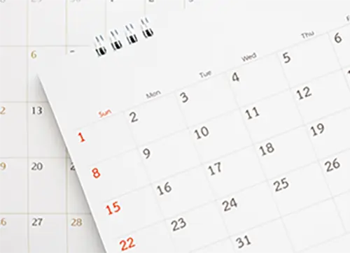 Close-up of two overlapping monthly calendar pages showing dates and days of the week in a clean, minimal design.