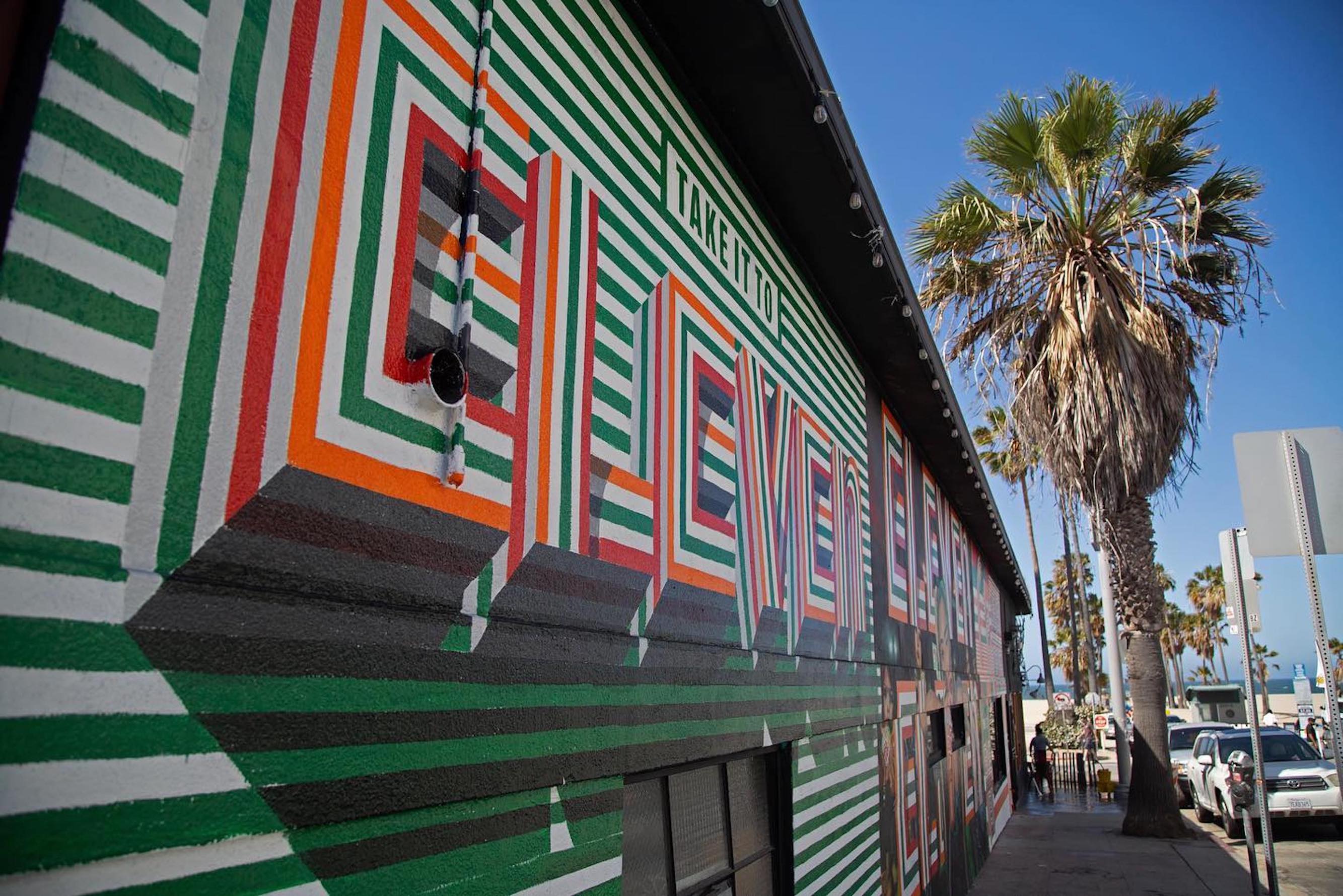 Angled street view of completed 7-Eleven Take it to Eleven hand-painted advertisement on Venice Beach building exterior