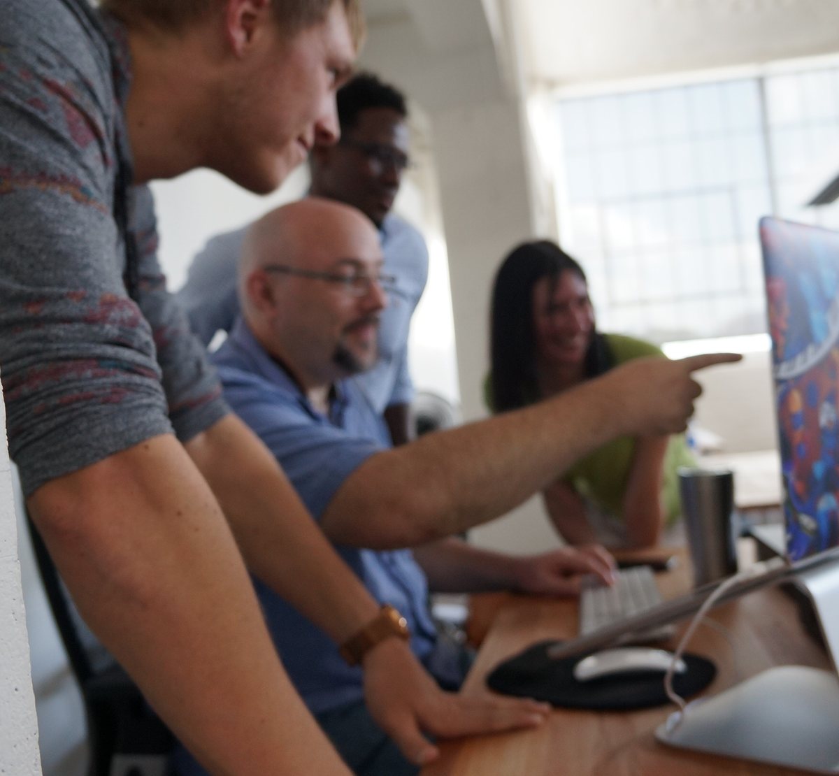 A VAULT engineer pointing at a screen while explaining an agent design to the team