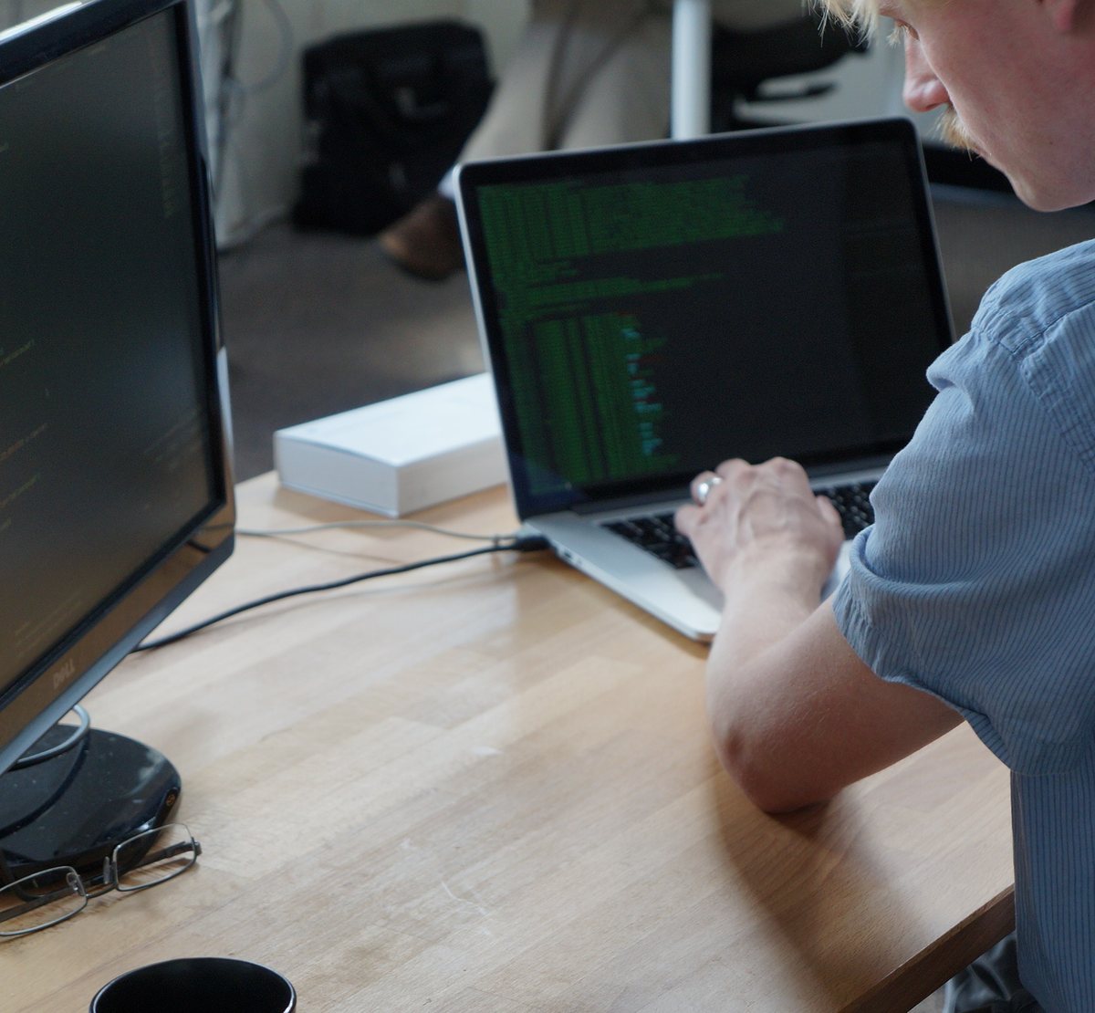 A VAULT developer writing code on a laptop in the Chicago office