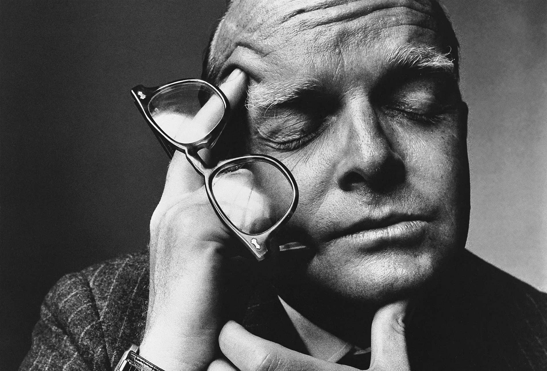 Man thinking with glasses in his hands