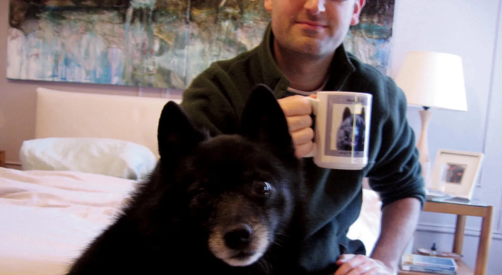 Man holding coffee mug with dog