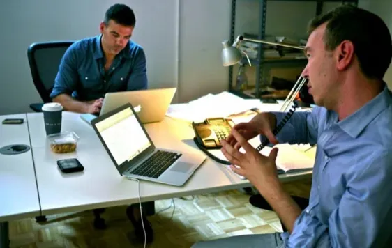 Friends working on a firm with a Macbooks
