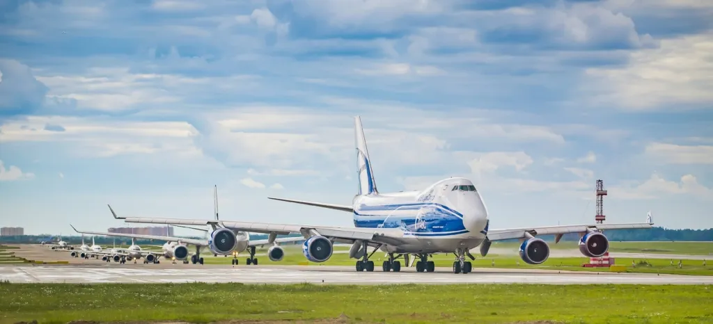 A queue of jet commercial aircraft on the taxiway of Sheremetyevo Airport waiting for takeoff. In the foreground is an AirBridgeCargo Boeing 747-8F. Moscow region, Russia - July 22, 2015