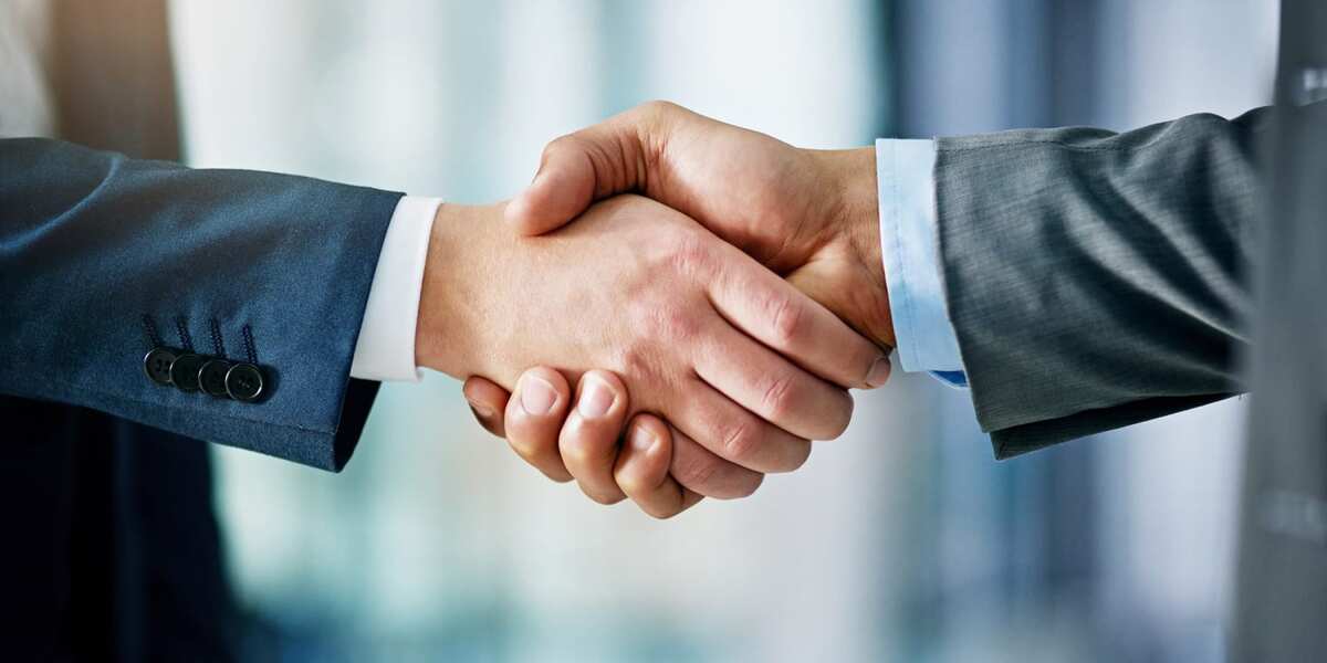 Business team with a professional production company hand shakes for partnership.