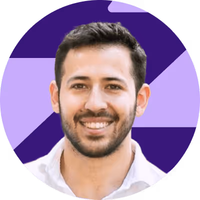 a man with a beard smiling in a purple circle